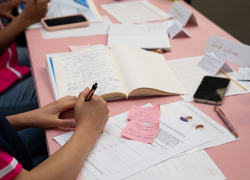 Desk with notebooks and hand writing on paper